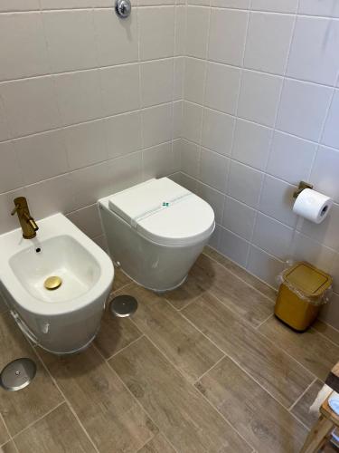 a bathroom with a toilet and a sink at Hotel Melydà in Pozzuoli