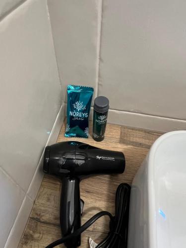 a hair dryer sitting on the floor next to a wall at Hotel Melydà in Pozzuoli