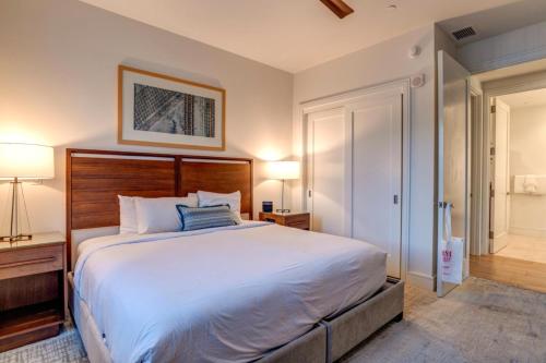 a bedroom with a large white bed and two lamps at Honua Kai Luana Condos by KBM Resorts in Kaanapali