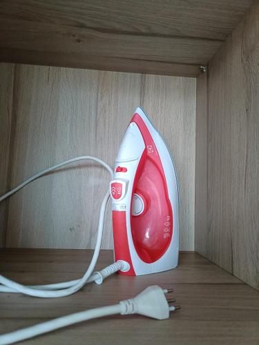 a red and white blow dryer sitting on a shelf at Apartamento in Natal