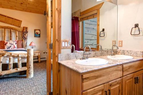 a bathroom with two sinks and a bedroom at KBM Resorts Timber Wolf Lodge Mountain Elegance with Gas Fireplace Common Hot Tubs Near Canyons Village TWL-5b in Park City