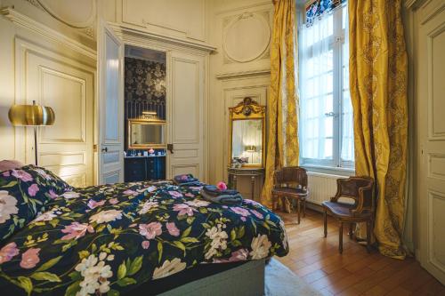 une chambre avec un lit avec une couette fleurie dans l'établissement Hôtel particulier Hôtel Blancler, à Saumur