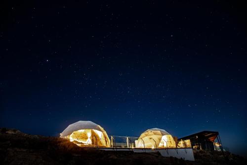 two domed buildings on top of a hill at night at Hotel de Sal Luna Salada in Colchani
