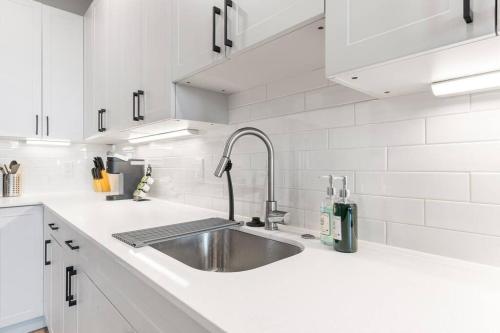 a kitchen with a sink and white cabinets at Near Fishtown and Old City - King Bed - City Views in Philadelphia