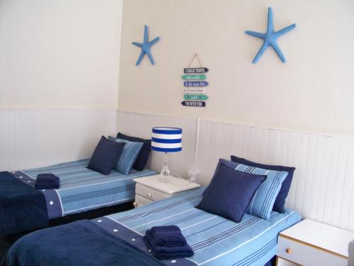 two blue beds in a room with blue stars on the wall at Jetty Self-Catering in Swakopmund