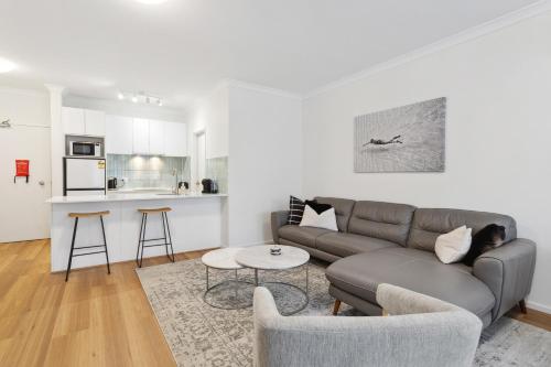 a living room with a couch and a kitchen at REGL20/11 - East Perth Escape in Perth