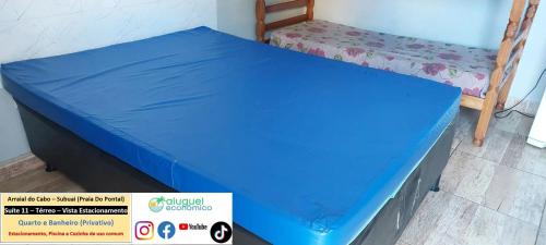 a bed with a blue sheet on top of it at Arraial do Cabo – Subuai Village - Aluguel Econômico in Arraial do Cabo