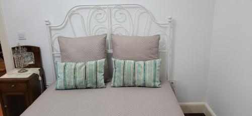 Bett mit weißem Kopfteil und Kissen in der Unterkunft Refúgio do Santa in Calheta
