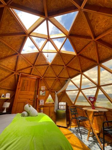 a room with a green bed in a yurt at Glamping Brillo de Luna in Guatavita