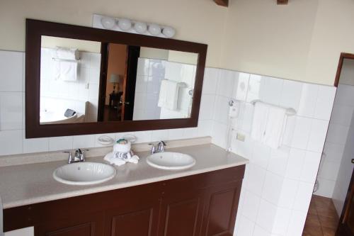 a bathroom with two sinks and a mirror at Hotel Pensión Bonifaz in Quetzaltenango