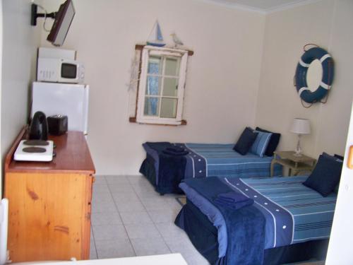 a room with two beds and a refrigerator at Jetty Self-Catering in Swakopmund