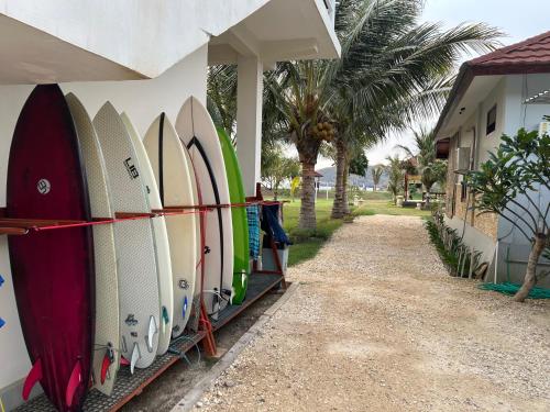 a bunch of surfboards are lined up against a wall at Mama Nings Beach Hotel in Sekongkang