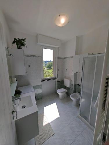 a bathroom with two toilets and a shower and a window at AlysNest in Albizzate