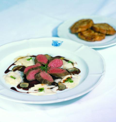 a white plate of food on a table at Romantik Hotel Zum Klosterbräu in Neuburg an der Donau