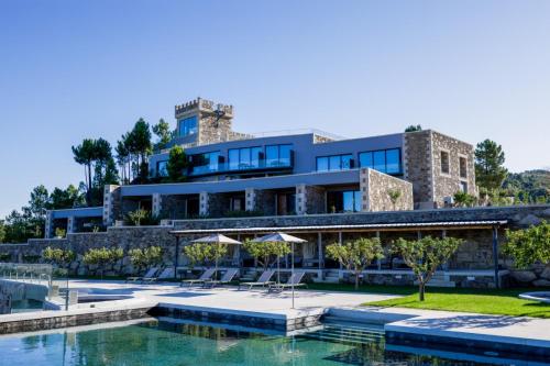 a house with a swimming pool and a building at Pedra Pura Resort in Chaves