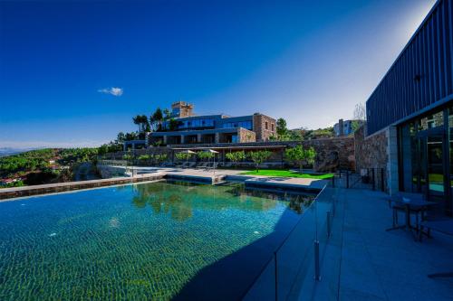 a large swimming pool next to a building at Pedra Pura Resort in Chaves