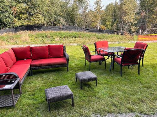 a group of chairs and a red couch and a table at Rita's Kunjo - 2BR, 3BD, 2WR, Full Ktchn, Living in Whitby