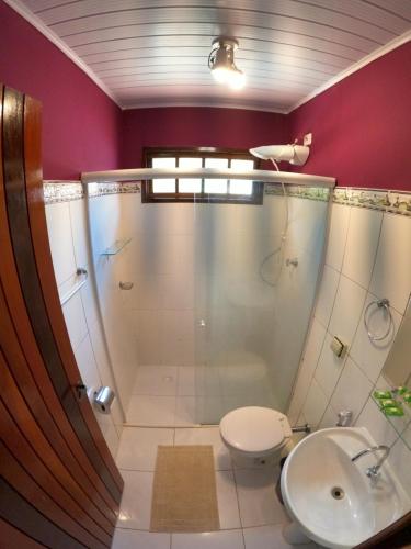 a bathroom with a shower and a toilet and a sink at Casa Bawa in Ubatuba