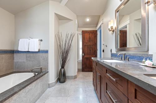 ein Badezimmer mit zwei Waschbecken und einer Badewanne und einem Spiegel in der Unterkunft KBM Resorts PWS-957 Luxurious 3bd Old Town Home 2 family rooms BBQ PWS-957 in Park City