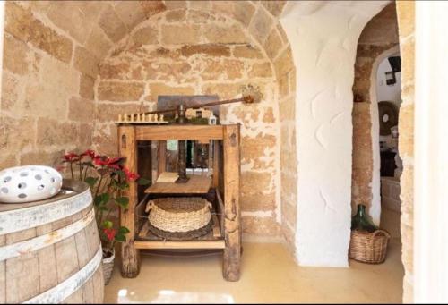 a room with a table and a stone wall at Trappito Stracca Agriturismo in Alezio