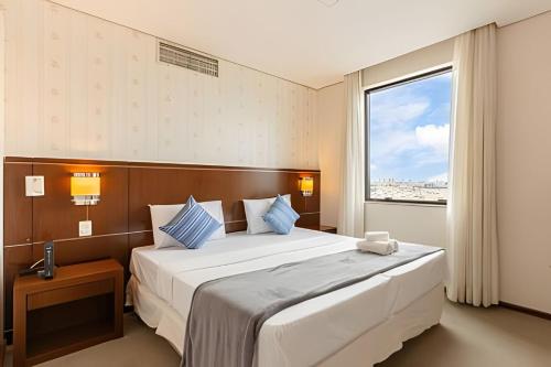 a bedroom with a large bed and a window at Flat moderno prox. Alphaville 1501 in Osasco