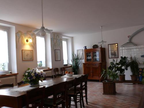 a dining room with a table and chairs and windows at B&B Leon D'Oro in Pusiano
