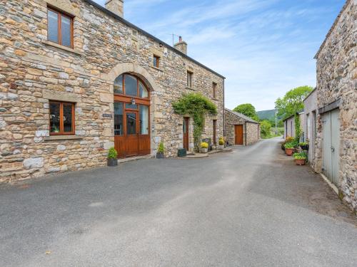 an empty street in a stone building with a driveway at Warth Barn - Uk44211 in Ingleton