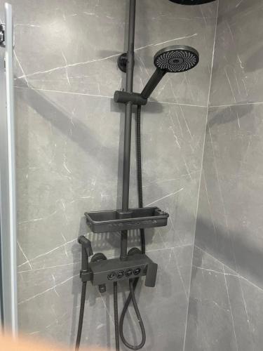 a shower in a bathroom with a shower head at Newly built modern flat with free parking close to London Luton airport and L&D hospital in Dunstable