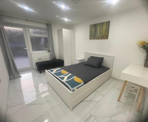 邓斯特布尔Newly built modern flat with free parking close to London Luton airport and L&D hospital的卧室里有一张床和一张书桌
