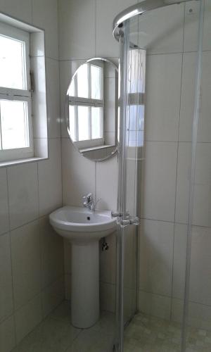 a white bathroom with a sink and a mirror at Jetty Self-Catering in Swakopmund