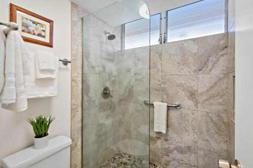 Un baño con ducha con puerta de cristal. en Royal Kahana 1015, en Kahana