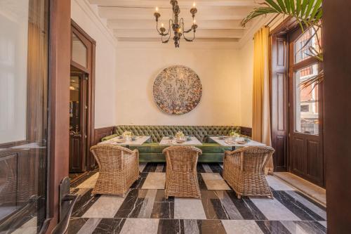 a dining room with a table and wicker chairs at Casa Kloster Hotel Boutique in Guanajuato