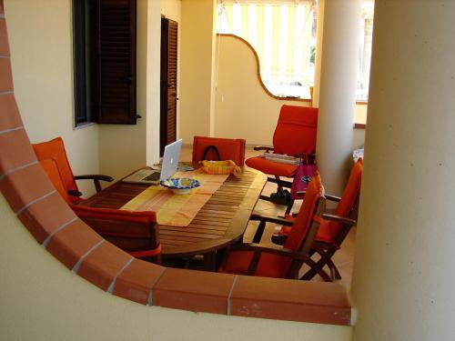 a dining room with a table and red chairs at Summer Holidays Apartments in Foce Varano