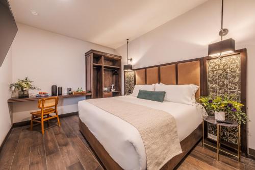 a bedroom with a large bed and a desk at Casa Kloster Hotel Boutique in Guanajuato