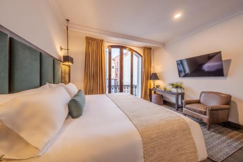 a hotel room with a large bed and a chair at Casa Kloster Hotel Boutique in Guanajuato