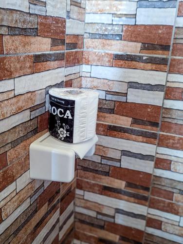 a toilet in a bathroom with a brick wall at La perle océanique Calme et moderne près de l'océan in Lomé