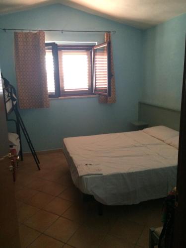 a bedroom with a bed and two windows at Summer Holidays Apartments in Foce Varano