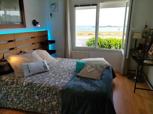une chambre avec un lit avec vue sur l'océan dans l'établissement Apartment in Plouguerneau by Sandy Beach, à Plouguerneau