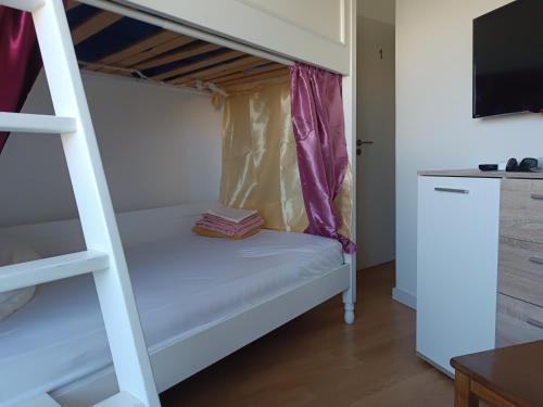a bunk bed with a ladder in a room at Sams Rooms - Solo Female Guest House in Amadora