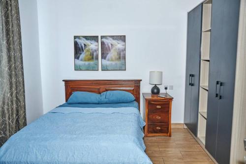 阿克拉iFORA Homes- Stylish 3 Bedroom Condo near A&C Mall的一间卧室配有床、梳妆台和两张照片