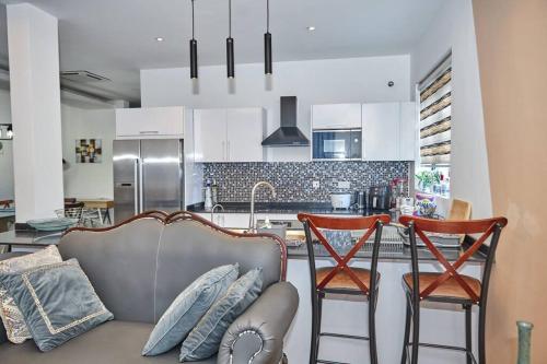 阿克拉iFORA Homes- Stylish 3 Bedroom Condo near A&C Mall的厨房设有带沙发和椅子的客厅