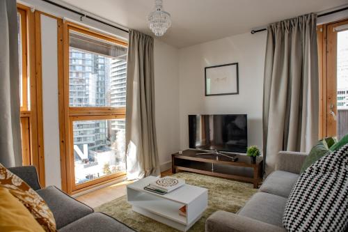 a living room with a couch and a tv at Luxury cosy apartment with stunning London skyline views! in London