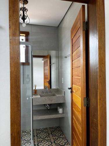 a bathroom with a sink and a mirror at Serra Vale D l 2 Suítes l Centro Histórico l Garagem in Tiradentes