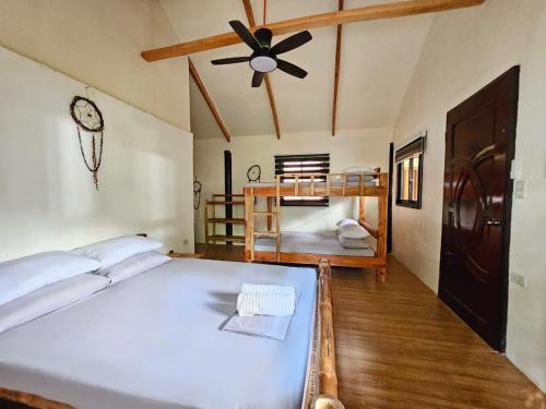 a bedroom with a bed and a ceiling fan at Big BamBoo Beach Resort Sipalay in Sipalay
