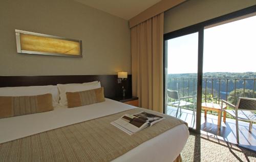 a hotel room with a bed and a balcony at Panoramic Grand - Iguazú in Puerto Iguazú
