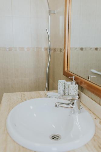 a bathroom with a white sink and a mirror at Villa Lanzarote Zen in Playa Blanca