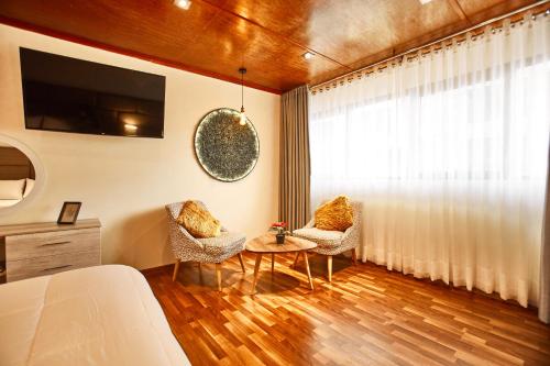 a room with a bed and a table and a window at Inti Tampu Inn in Cusco