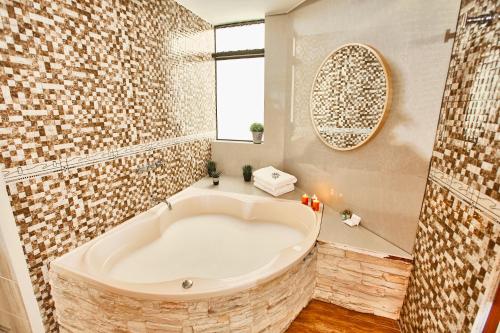 a large white tub in a bathroom with a window at Inti Tampu Inn in Cusco