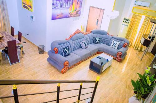 a living room with a blue couch and a table at Dej's Luxury Apartment House 1 in Lekki