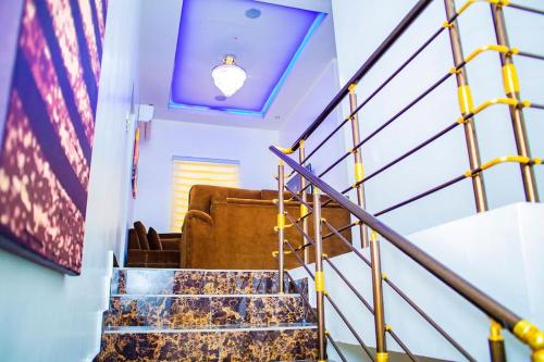 a spiral staircase with a blue ceiling and a light at Dej's Luxury Apartment House 1 in Lekki